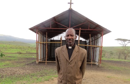 Pastor standing in front of a church