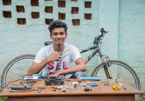 boy-showing-off-his-tools-with-a-bike-in-the-background-4x3